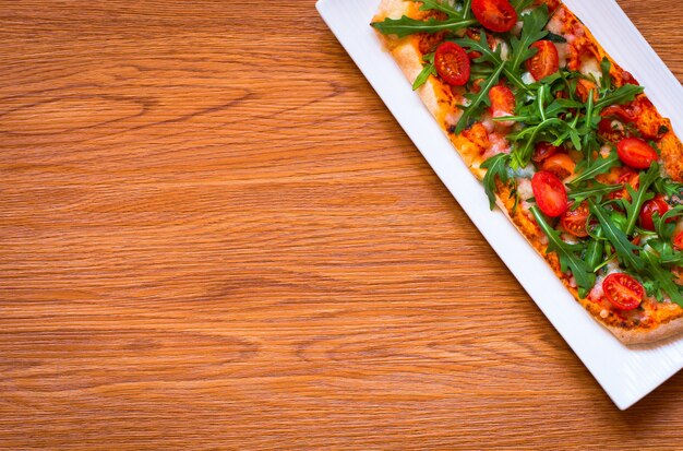 Maison bonne pizza fraîche avec des tomates, rucola et mozzarell