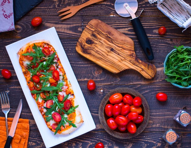 Maison bonne pizza fraîche avec des tomates, rucola et mozzarella