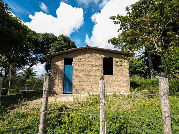 Maison de boue isolée dans une ferme rurale aux beaux jours avec un ciel bleu