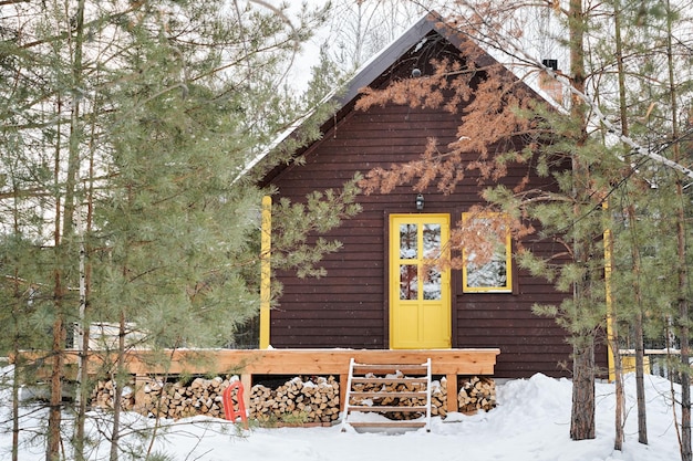 Photo maison de campagne en bois marron avec porte jaune et petite fenêtre dans la forêt