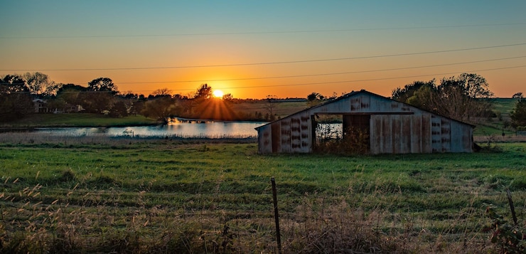 Photo maison sur le champ contre le ciel au coucher du soleil
