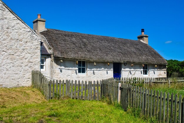 Photo la maison sur le champ contre le ciel bleu