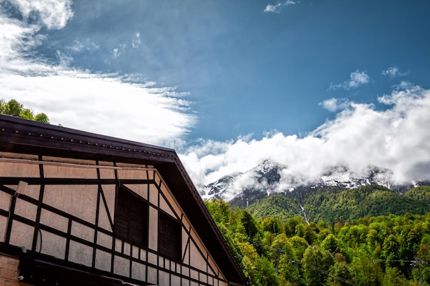 Maison à colombages sur fond de forêt verdoyante et de hautes montagnes enneigées