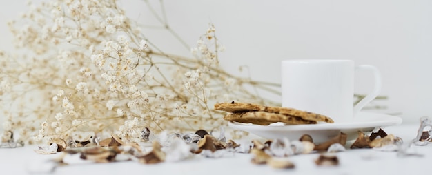 Maison confortable avec une tasse de café et une branche de fleurs. Hygge hiver ou automne