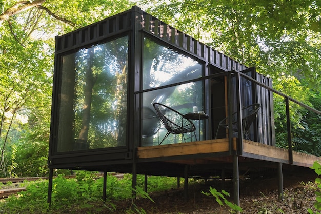 Maison conteneur maritime avec terrasse et chaises de jardin en osier