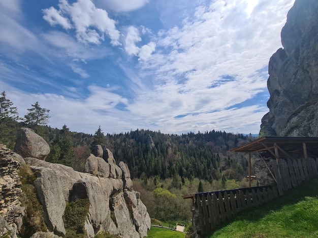 Une maison dans les montagnes avec un ciel bleu et des nuages