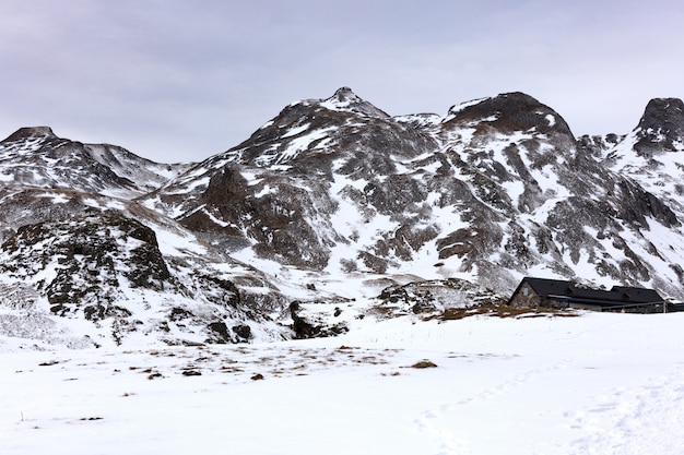 Photo maison dans les montagnes enneigées
