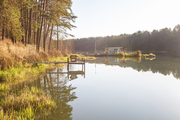 Maison de débarcadère sur une jetée en bois dans l'eau en forêt en soirée