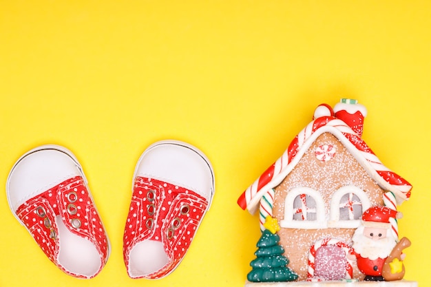 Maison du Nouvel An avec des chaussures pour enfants de couleur rouge à pois blancs sur fond jaune