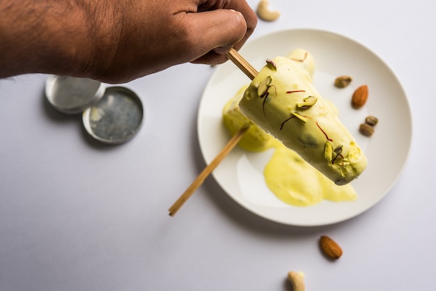 Maison du Rajasthan prêt à manger matka kulfi - safran ou kesariya aromatisé à la pistache, à la noix de cajou et aux amandes, mise au point sélective