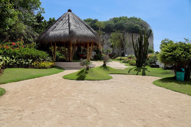 Maison écologique en bambou traditionnelle au milieu d'un jardin sablonneux