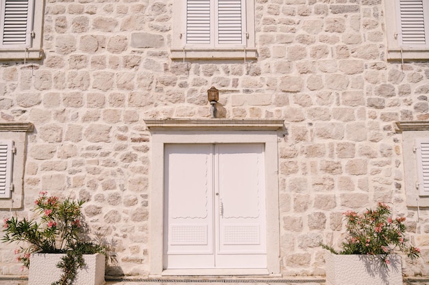 Maison avec une façade en pierre volets sur les fenêtres et une porte blanche perast monténégro