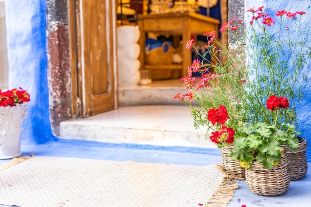 Maison grecque traditionnelle comme boutique, architecture cycladique, Santorin, Grèce. Fleurs et ancienne entrée