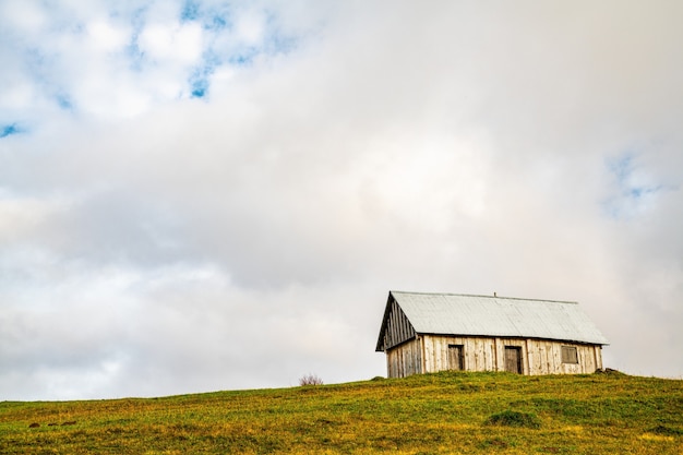 Une Maison Grise Solitaire Se Dresse Sur Un Pré Vert Humide Parmi Un épais Brouillard Gris