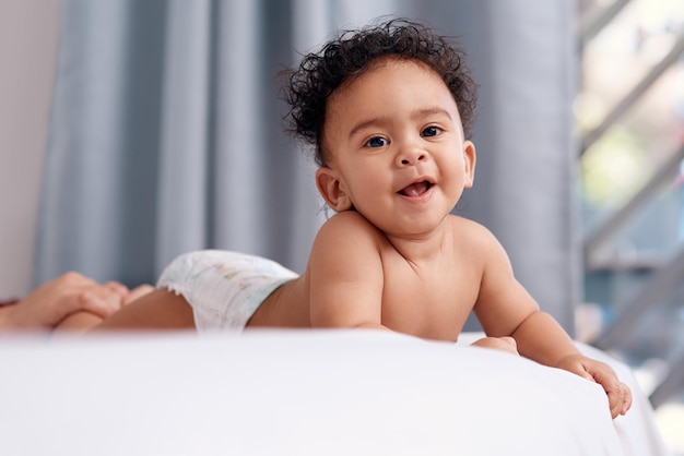 La maison heureuse et le portrait du bébé dans la chambre à coucher pour le développement du bien-être et le repos le week-end mignon innocent et le visage d'un enfant adorable avec une couche pour une paix confortable et la croissance dans l'enfance