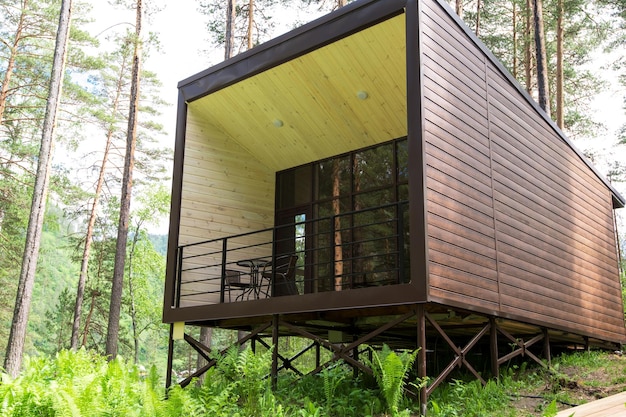 Maison ou hôtel avec fenêtres panoramiques dans une forêt de pins belle matinée d'été avec nature ensoleillée