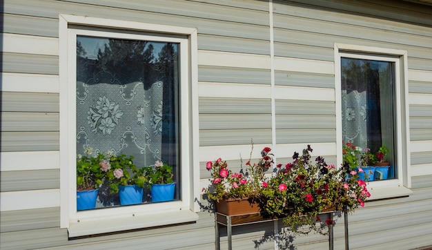 Une maison avec une jardinière avec des pots de fleurs bleus dessus