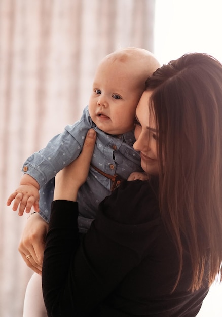 À la maison, la jeune maman embrasse la fille qui s'occupe des parents et tient le bébé dans les bras