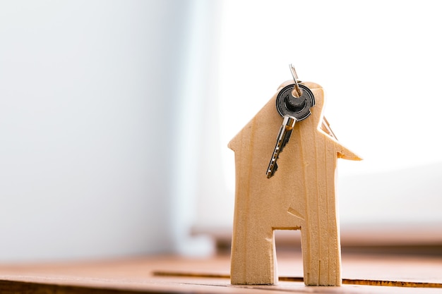 Photo maison de jouet en bois et clés de la maison se bouchent. concept immobilier