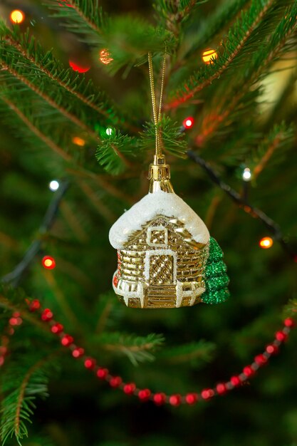 Une Maison De Jouets Est Accrochée à Une Branche D'un Arbre De Noël