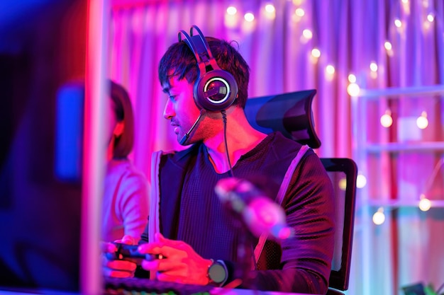 À la maison, un joueur portant un casque s'amuse à jouer à un jeu en ligne en streaming