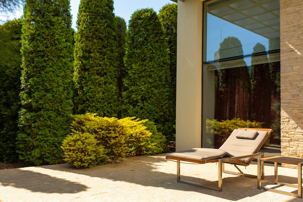 Maison de luxe, cour bien entretenue avec un jardin verdoyant et chaises longues confortables pour se détendre dans le jardin