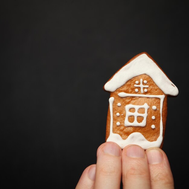 Maison en main masculine isolée sur fond noir