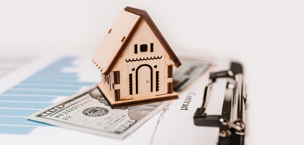 Maison miniature et argent sur documents. Investissement, immobilier, maison, logement