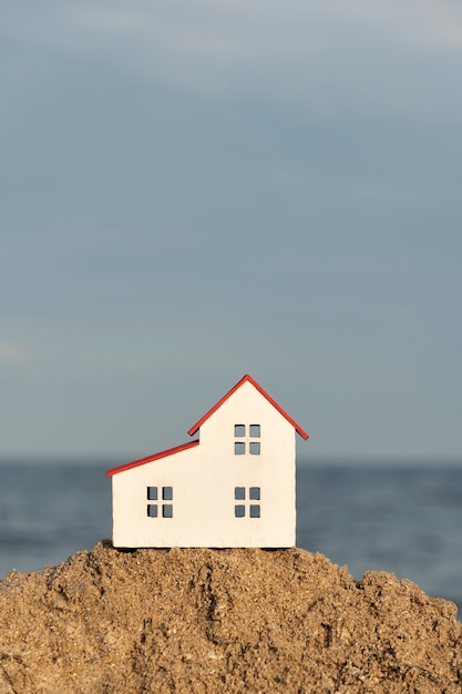 Maison miniature moderne sur sable de mer