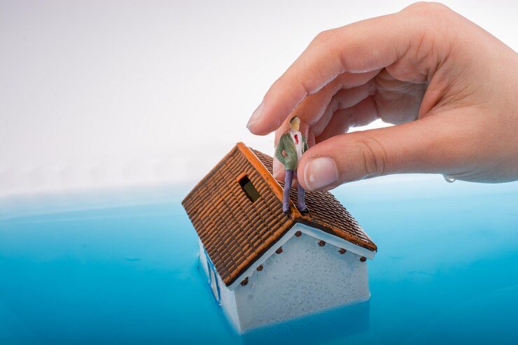 Photo maison modèle et figurines d'un homme dans l'eau