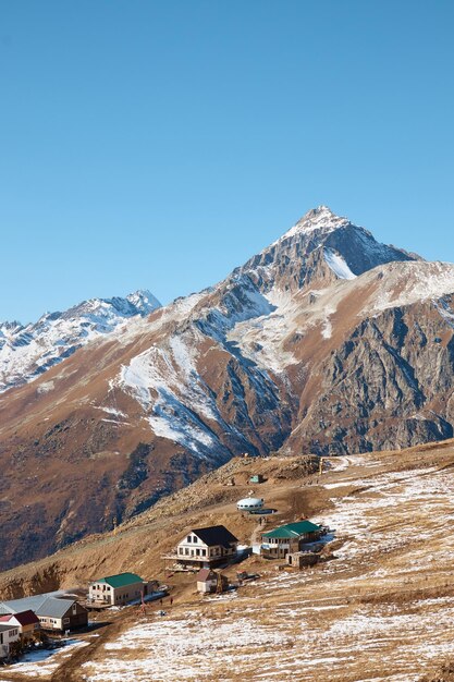 Une maison à la montagne, un village sur un versant, des falaises de neige, la vie à la montagne, une maison au sommet d'une montagne