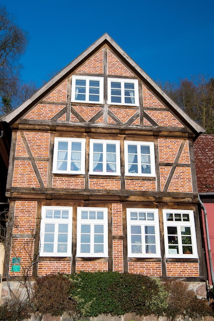 Photo maison de murs de briques rouges avec fenêtres par beau temps à l'extérieur dans la campagne sur fond de ciel bleu. concept immobilier, architecture, construction et bâtiment