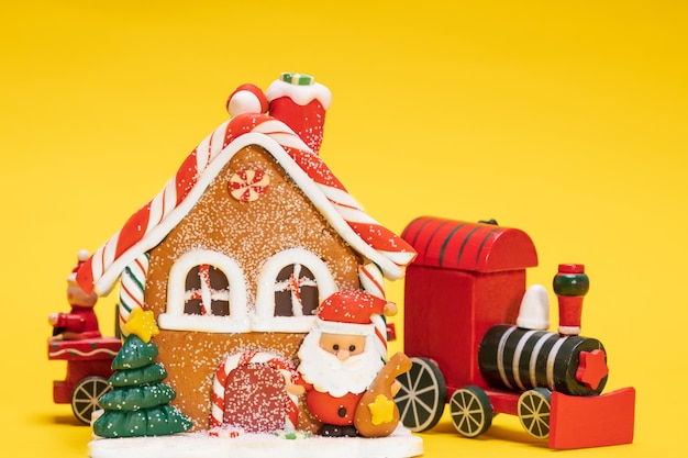 Maison de noël jouet avec train du père noël sur fond jaune