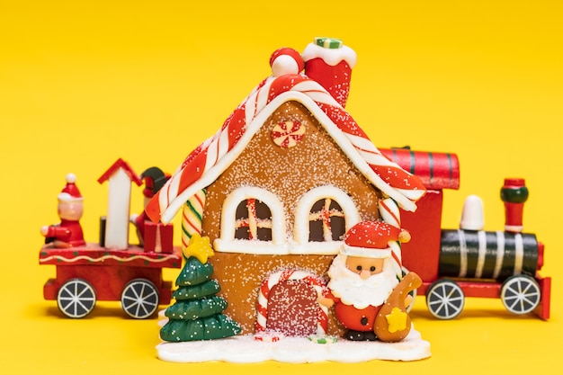 Maison de noël jouet avec train du père noël sur fond jaune