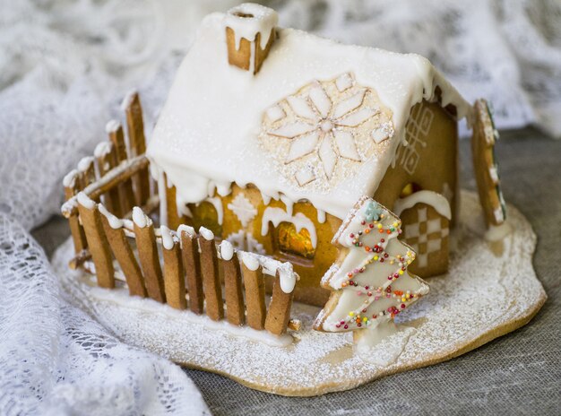 Photo maison en pain d'épice de noël décorative dans la neige
