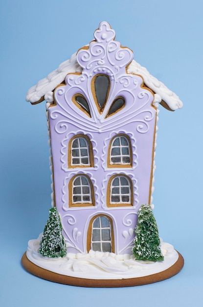 Maison de pain d'épice de Noël isolée sur fond bleu