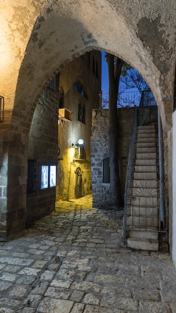 Photo maison en pierre blanche sur rue étroite du vieux yafo (jaffa) la nuit. tel-aviv, israël.