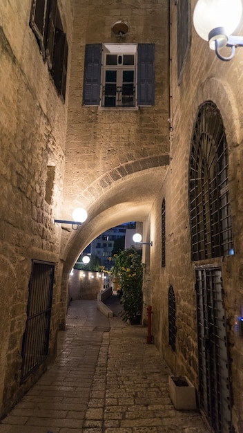 Photo maison en pierre blanche sur rue étroite du vieux yafo (jaffa) la nuit. tel-aviv, israël.