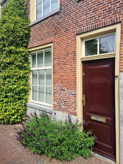 Une maison avec une porte rouge qui a une porte qui dit "Bienvenue à l'avant".