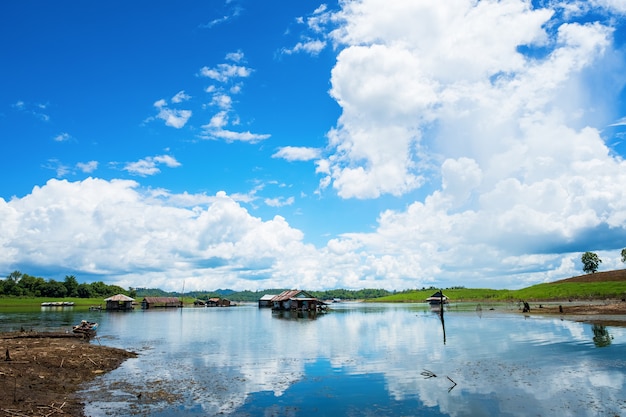 La maison de radeau sur le front de mer est entourée de fond de ciel bleu, province de Kanchanaburi, Thaïlande