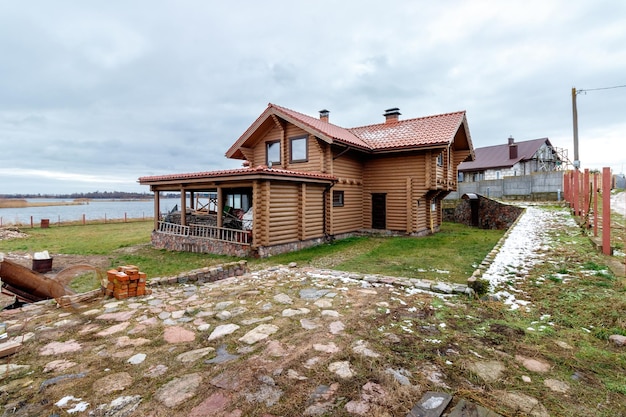 Une maison en rondins de bois au bord d'un grand lac Construction en cours