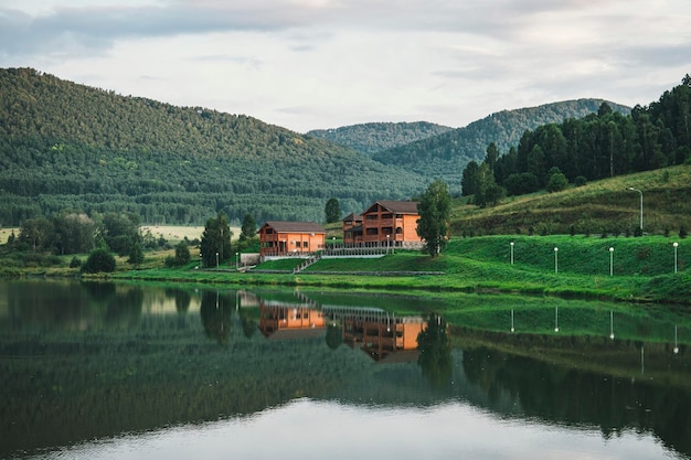 Maison en rondins à l'extérieur de la ville pour les loisirs Région écologiquement propre Reflet de la maison dans l'eau d'un lac clair Beau paysage avec chalet près d'un lac et d'arbres