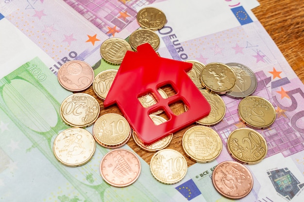 Maison rouge sur les billets de banque euro pile pile pack concept immobilier dépenses achat de propriété