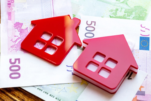 Maison rouge sur le paquet de billets en euros. concept immobilier