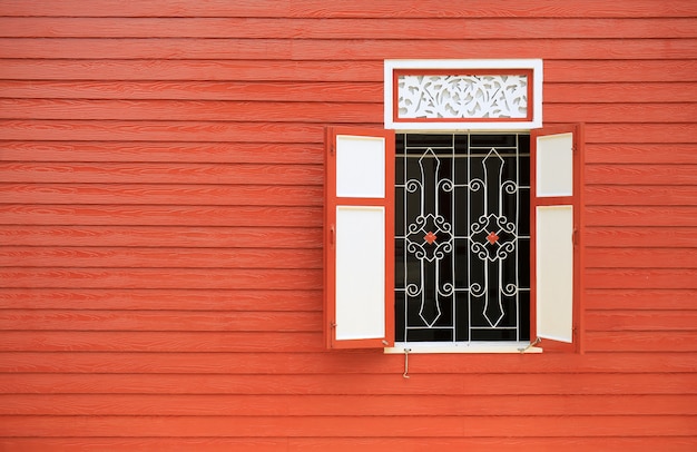 Maison de style vintage avec mur en bois et fenêtres ouvertes.