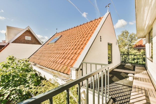 Une maison avec un toit rouge et un balcon