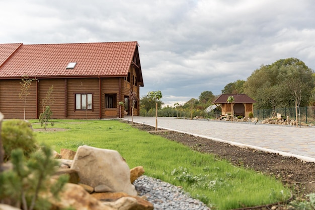 Une maison avec un toit rouge et une pelouse verte devant