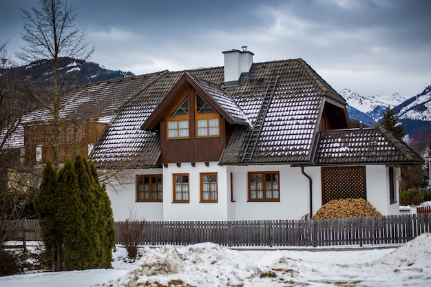 Maison traditionnelle en bois dans les Alpes autrichiennes au jour de neige