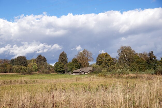 Maison typique isolée avec une grange dans un village biélorusse