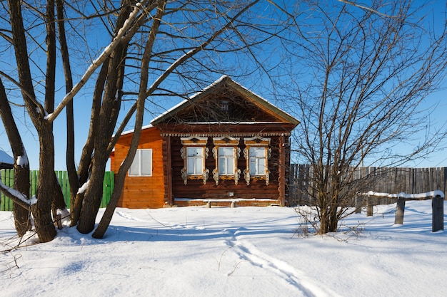 Maison de village avec fenêtres gelées par une froide journée d'hiver